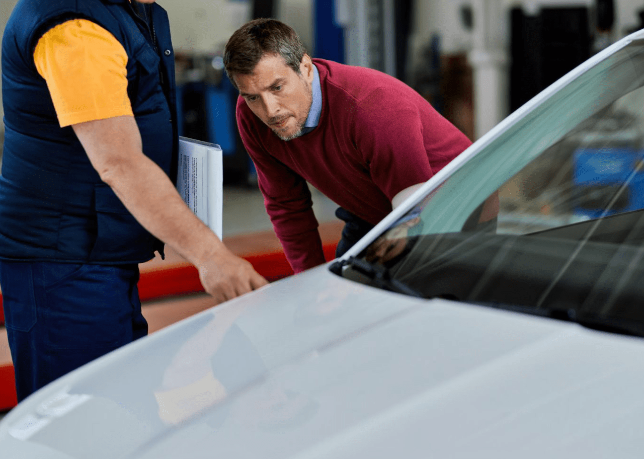 mid-adult-man-auto-repairman-analyzing-malfunction-car-workshop